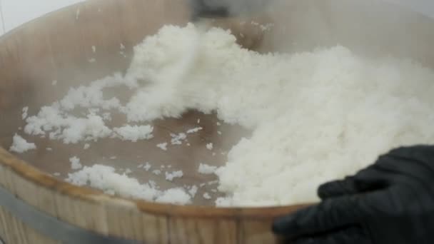 cocina revuelve arroz caliente en un tazón de madera - Metraje, vídeo