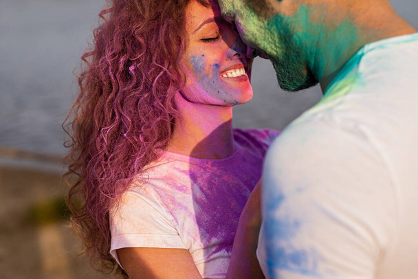 Woman touching noses with boyfriend during paint party - Fotoğraf, Görsel