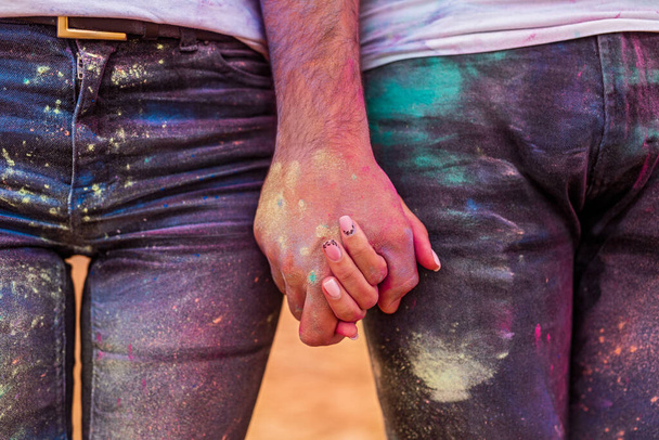 Crop couple holding hands during paint party - Photo, image