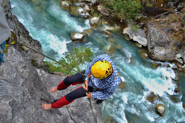 Climbing the majestic Star Chek multi-pitch route south of Whistler. Young man rappels beautiful climbing route above the wild river. - Photo, Image