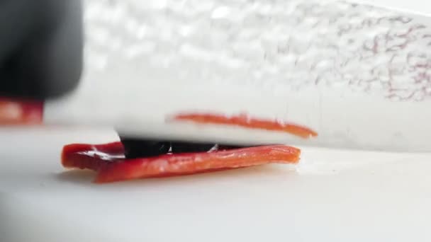 le cuisinier coupe le poivron rouge avec un beau couteau - Séquence, vidéo