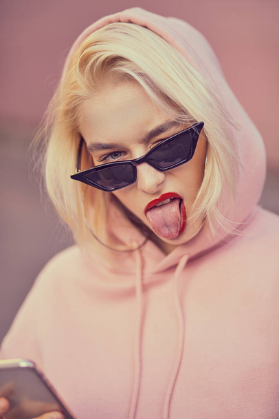 beautiful blonde woman in sunglasses with pink lips and glasses on the street - Foto, Imagen