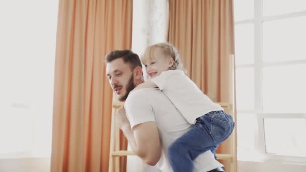 Happy family loving dad giving cute little funny kid daughter piggyback ride spinning at home. Fathers day concept - Footage, Video