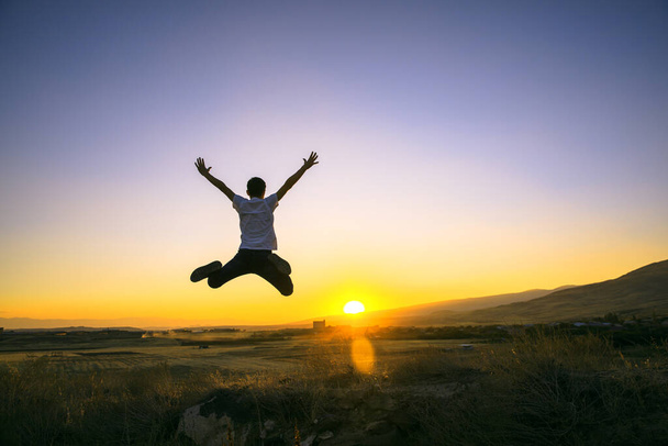 Man silhouette jump in the sky with sunset background. - Foto, Imagem
