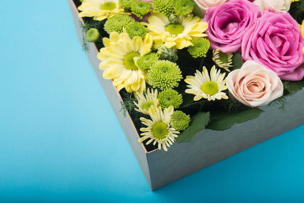 όμορφη συσκευασία δώρου με λουλούδια. αξεσουάρ διακόσμησης γάμου. μπλε φόντο - Φωτογραφία, εικόνα
