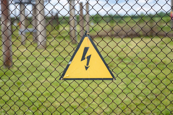 Σημάδι κινδύνου υψηλής τάσης σε φράχτη. - Φωτογραφία, εικόνα