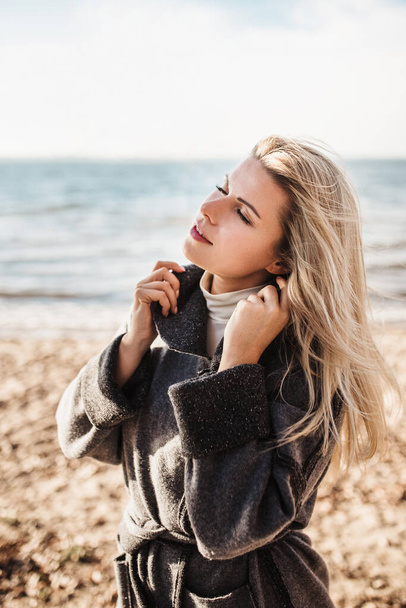 A young charming Slavic woman enjoys the warmth and sea air with her eyes closed - happiness is in pleasure - Photo, Image