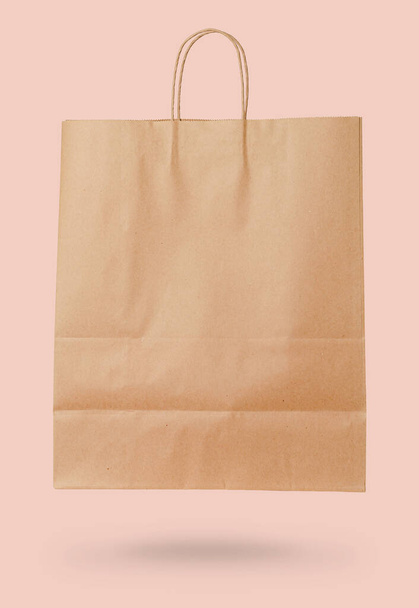 Bolsa de papel artesanal sobre fondo rosa. Concepto de venta
. - Foto, Imagen