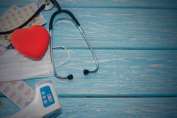 Ein Herz mit Stethoskop liegt auf einem hölzernen Hintergrund. Gesundes Herz - Foto, Bild