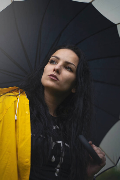 Sarı yağmurluklu güzel genç kız, bahçede şemsiyesi, yağmurlu bahar, güzel ve şık kıyafetler, moda - Fotoğraf, Görsel