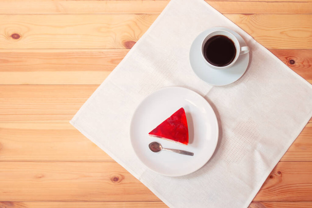 Piece of strawberry cake and cup of coffee on wooden table. Top view, copy space. - Photo, Image