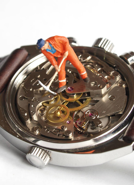 kis játékmunkás figura felett vintage óra gépezet: idő pénz koncepció             - Fotó, kép