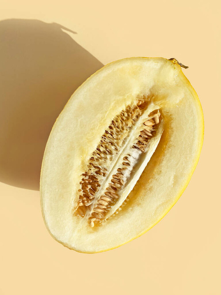 half of melon with long shadow on pastel background, top view - Fotografie, Obrázek