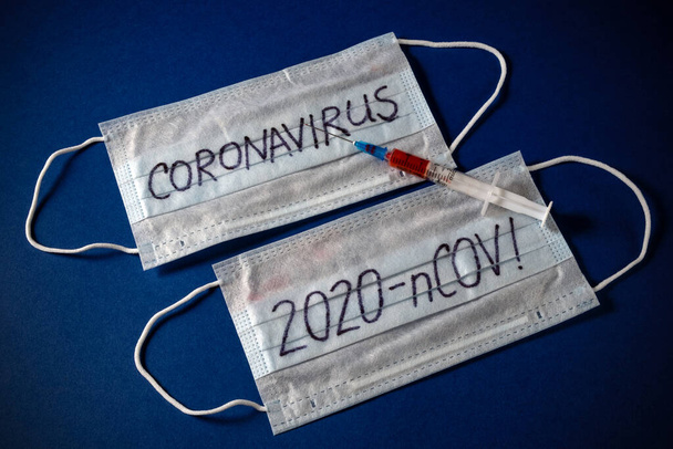 positive analysis of the Chinese epidemic against the background of a protective mask for a syringe, a vaccine. coronavirus from wuhan province of china. deadly epidemic nCOV - 2020 on a blue background. - Foto, afbeelding