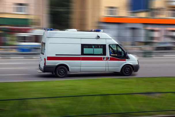 car of an emergency medical service goes on the city street - Fotoğraf, Görsel