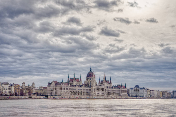 Hungarian Parliament facing Danube with clouds overhead in Budapest winter morning time - Photo, Image