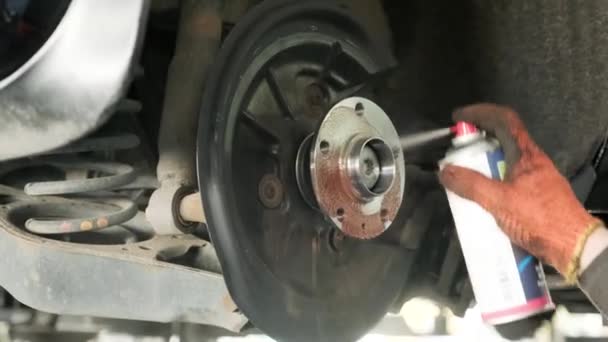 mechanic spray chemical to clean brake during tyre replacement service - Footage, Video