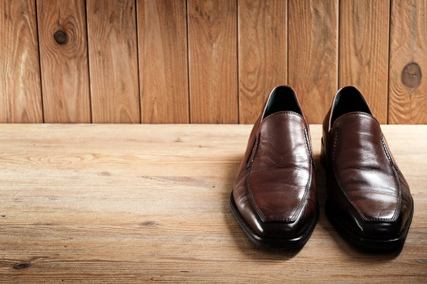 男性用茶色の革の靴、木製の背景の高級革の靴 - 写真・画像
