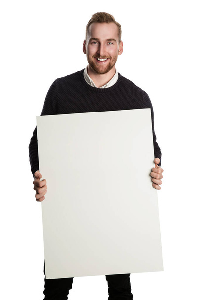 Smart and handsome Caucasian businessmanin casual clothes holding a white sign board. Standing against a white background. - Фото, изображение