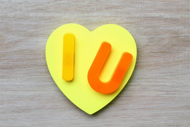 Litery I i U z pustą symboliczną naklejką w kształcie serca. Krótka wiadomość Kocham cię. Kontekst - Zdjęcie, obraz