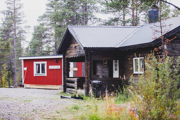 Vista del Camping sueco clásico con casas tradicionales de madera cabaña roja, Laponia, Sueco del Norte
 - Foto, Imagen