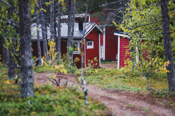 View of Classical swedish Camping site with traditional wooden red cabin cottage houses, Lapland, Northern Swede - Foto, Imagen