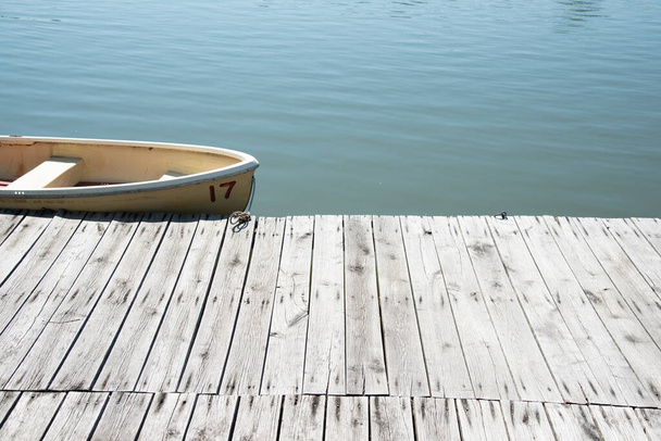 ボートと水の背景を持つ木製の桟橋 - 写真・画像