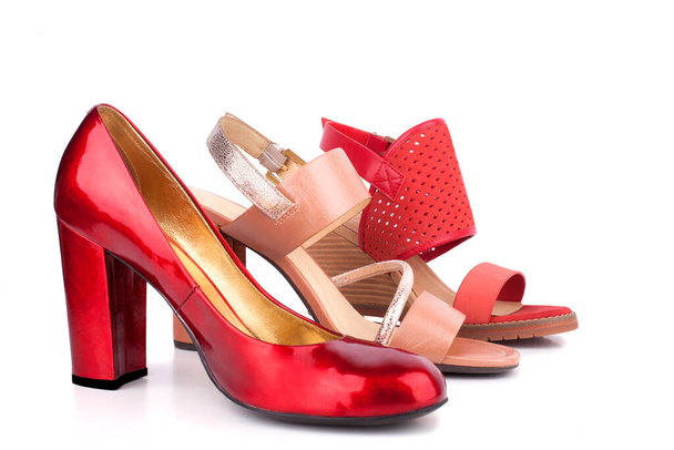 Красные, бежевые и оранжевые женские туфли и сандалии с высокими каблуками на продажу вид сбоку на белом фоне, изолированные крупным планом
 - Фото, изображение