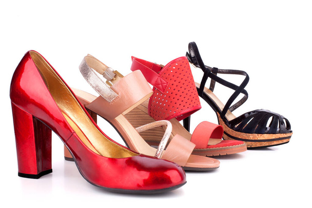 Κόκκινα, μπεζ και μαύρα γυναικεία παπούτσια και σανδάλια με ψηλά τακούνια για πώληση πλαϊνή άποψη σε λευκό φόντο απομονωμένο από κοντά - Φωτογραφία, εικόνα