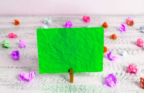 Retângulo quadrado em forma de papel colorido com espinha de pano ou bola de papel em um fundo leve. Nota enrugada colorida espalhada ao redor da mesa. Material de escritório em uma mesa
. - Foto, Imagem