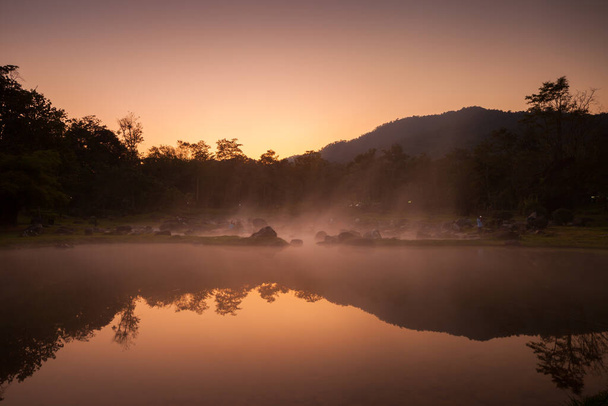 Una fuente natural de agua clara en la mañana con niebla nublada situada frente a la montaña en el norte de Tailandia. Concepto de lugar saludable
 - Foto, imagen