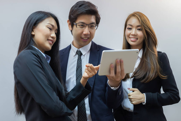 Los jóvenes empresarios se concentran en el iPad y sonríen con un fondo blanco
 - Foto, imagen