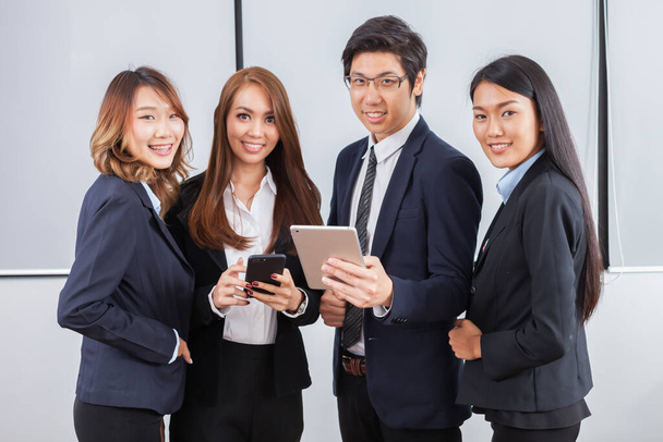 Jonge zakenmensen staat concentreren op iPad en glimlach met witte achtergrond - Foto, afbeelding