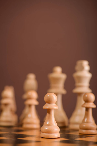 dřevěné šachové figurky na palubě hry. hnědé vinobraní pozadí - Fotografie, Obrázek
