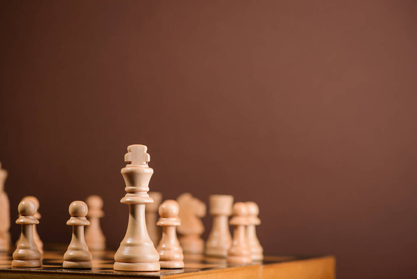 wood chess pieces on board game. brown vintage background - Φωτογραφία, εικόνα