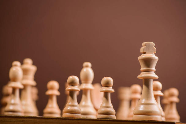 wood chess pieces on board game. brown vintage background - Φωτογραφία, εικόνα