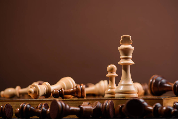 wood chess pieces on board game. brown vintage background - Zdjęcie, obraz