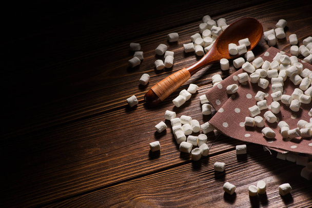 marshmallow doce branco com colher de madeira na mesa
 - Foto, Imagem