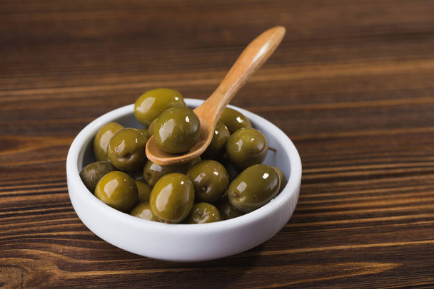olives fraîches dans un bol blanc sur une table en bois
 - Photo, image