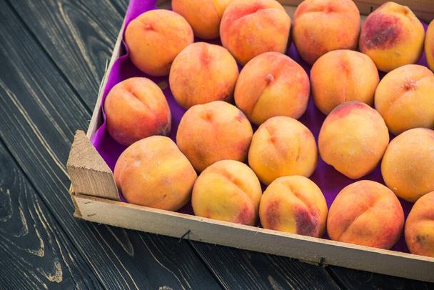 вкусный фруктовый персик в деревянной коробке на столе
 - Фото, изображение