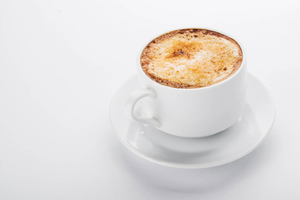 witte koffiebeker met schuim op witte achtergrond  - Foto, afbeelding