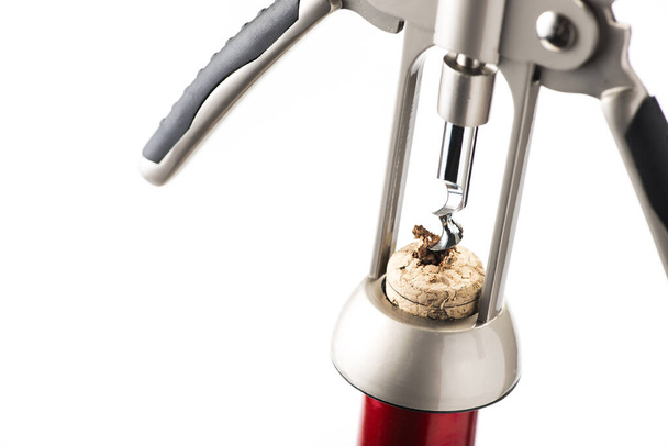 Red wine bottle opened by a corkscrew isolated on a white background - Fotoğraf, Görsel