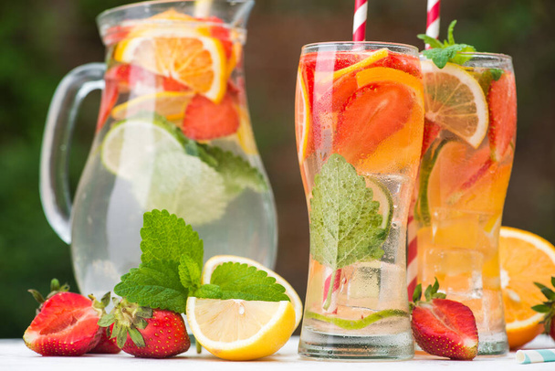 verfrissingsdrankje met mineraalwater met stukjes fruit in glas - Foto, afbeelding