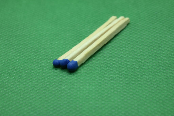three blue matches on green background - Photo, Image