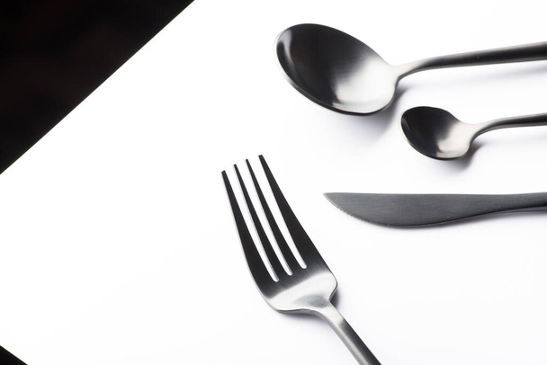 Cutlery set with black fork, knife and spoon isolated on white background - Valokuva, kuva
