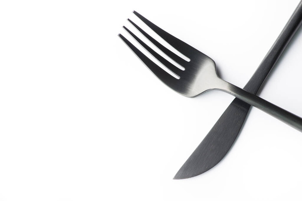 zwarte vork en mes geïsoleerd op witte achtergrond - Foto, afbeelding