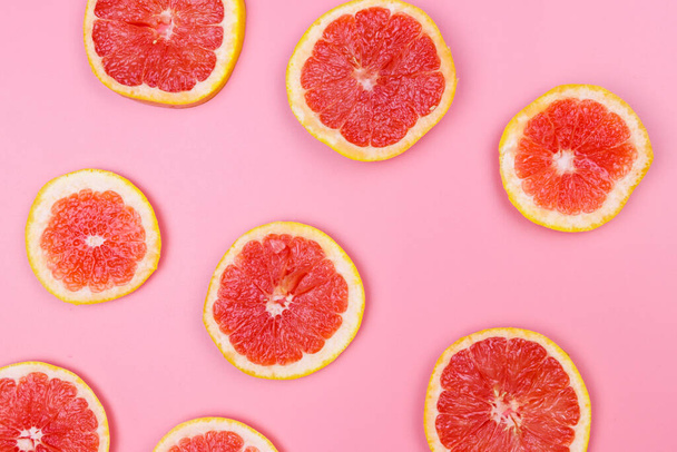 Slices of grapefruit on a pink background - Photo, Image