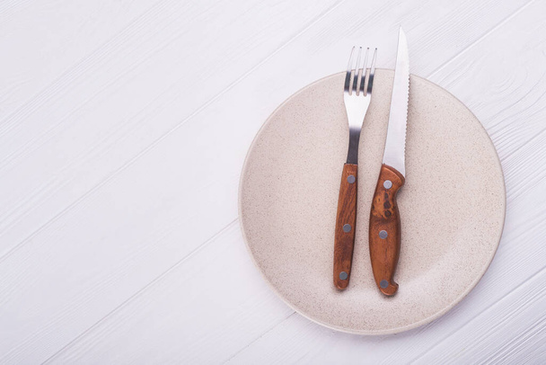 Пустая белая тарелка с ножом и вилкой. вид сверху
 - Фото, изображение
