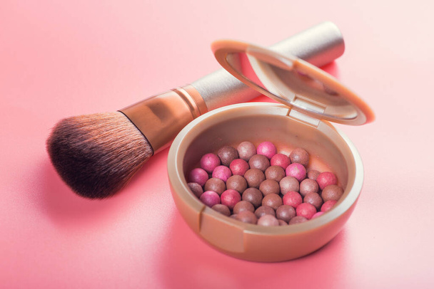 Puderkugeln und Kosmetikpinsel auf rosa Hintergrund. Beauty Make-up Produkt - Foto, Bild