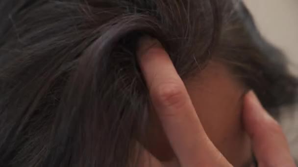 Middelbare leeftijd vrouw aanraken van haar donkere haar met grijs haar aan de wortels van het haar - Video